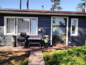 Una casa con una mesa y dos sillas en un patio. en Mustajärvi, en Konnevesi 13 fotos más