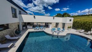 a swimming pool with chairs and a house at Equides club in Lesniki