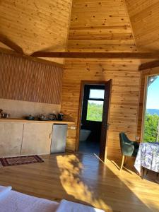 a wooden cabin with a kitchen and a dining room at Panoramic Wood Cabin in Itʼkhvisi