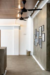 a ceiling fan in an empty room with art on the wall at SNUG Kuta in Kuta