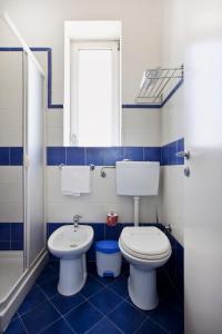 a blue and white bathroom with a toilet and a sink at Hotel San Martino in Cassibile