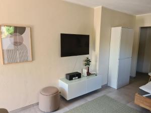 a living room with a television and a white cabinet at Ferienwohnung Zeitwinkel in Reil