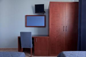 a bedroom with a desk with a tv and a cabinet at Hotel San Martino in Cassibile
