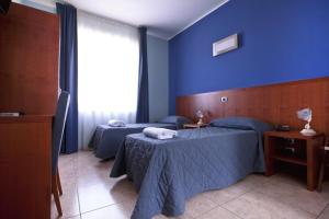 two beds in a room with blue walls at Hotel San Martino in Cassibile