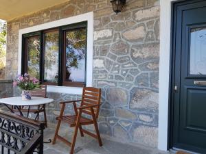 a patio with a table and chairs next to a stone wall at Villa Petri in Petra
