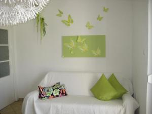 a white couch in a room with butterflies on the wall at Privathaus Marija in Dramalj