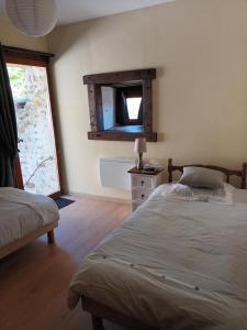 a bedroom with two beds and a mirror on the wall at Gite medieval St Jacques in Parthenay
