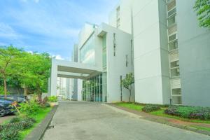 a white building with a car parked in front of it at DREAM INN Aeropolis By Reccoma in Teko