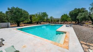 a swimming pool in a yard with a bench around it at Casa di Paolo by Rentbeat in Ceglie Messapica