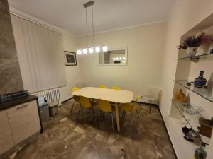 een keuken en eetkamer met een tafel en gele stoelen bij Authentic Belgrade Centre Apartment #5, Four bedrooms, One Full Bathroom, One Toilet in Belgrado