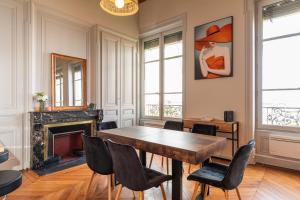 a dining room with a table and chairs and a fireplace at Smartstay - Vue panoramique sur Lyon et la saone in Fourvière +11 photos