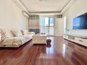 青岛Muju Qingdao Twin Family Room Near Metro Line 3 Near May Fourth Square MixC的带沙发和电视的客厅