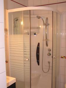 a shower with a glass door in a bathroom at Maison de caractère à Roscoff in Roscoff