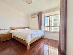 青岛Muju Qingdao Twin Family Room Near Metro Line 3 Near May Fourth Square MixC的带床和窗户的卧室