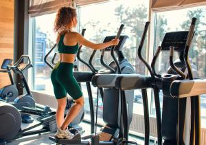 a woman running on a treadmill in a gym at MC One Stop Road Lounge Hotel in Xai-Xai