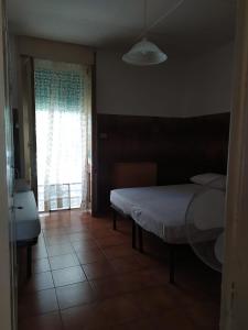 Un dormitorio con una cama y una ventana grande. en Casa vacanze le sirene, en Lido Conchiglia