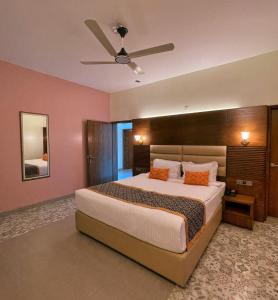 a bedroom with a large bed and a ceiling fan at Rass Resort Gazipur in Gazipur +14 photos