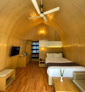 a bedroom with a bed and a ceiling fan at Rass Resort Gazipur in Gazipur