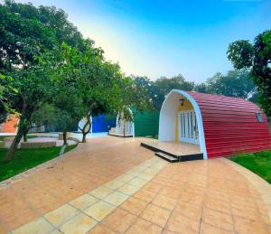 a small house with a red and white roof at Rass Resort Gazipur in Gazipur