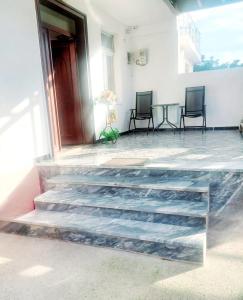 a porch with two chairs and a table and stairs at D Friendship Apartment in Shkodër