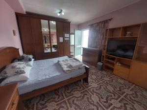 a bedroom with a bed and a flat screen tv at D Friendship Apartment in Shkodër