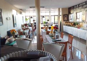 a dining room with tables and chairs in a restaurant at MC One Stop Road Lounge Hotel in Xai-Xai