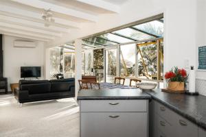 a kitchen and living room with a view of a living room at Driftwood Lodge Beachfront, Cable Bay Stays, Cable Bay, Northland in Coopers Beach