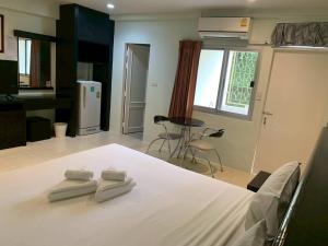 a bedroom with a bed with two towels on it at Orm Thong Hotel - SHA Plus in Kathu