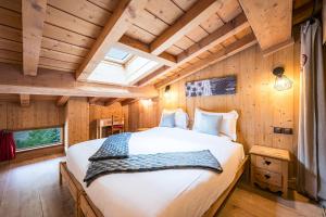 una camera da letto in una baita di tronchi con un grande letto di Chalet Vithos - Luxe, ski aux pieds a Les Bruyères