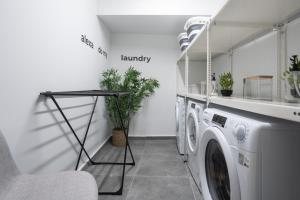 a laundry room with a washer and dryer at Silk Athens Urban Collection in Athens
