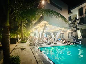 a swimming pool at a hotel with people sitting around it at NinhBinh Buffalo Hostel in Vũ Lâm