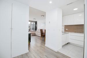 een keuken met witte kasten en een woonkamer bij Isea 2 in Calpe