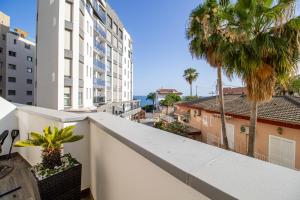 een balkon met palmbomen en uitzicht op de oceaan bij Isea 2 in Calpe