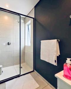 a bathroom with a shower with a glass door at Urban Elephant, The Rose in Cape Town