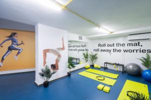 a fitness room with a poster of a woman running at Silk Athens Urban Collection in Athens