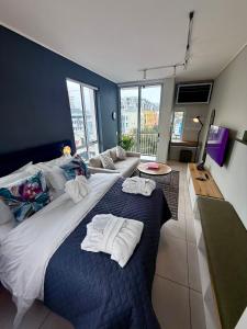 a bedroom with a large bed with towels on it at Urban Elephant, The Rose in Cape Town