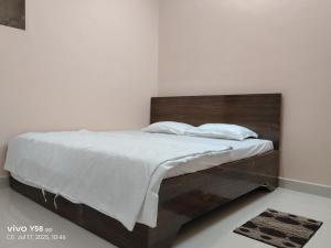 een bed met een houten hoofdeinde in een slaapkamer bij 5 Star Yatri Vishram Dormitory & Rooms in Jabalpur