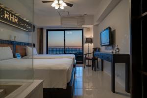 a hotel room with a bed and a desk and a television at Royal Hotel in Yomitan +150 photos