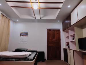 a room with a bed and a tv and a ceiling at Shanti Sojourn in Shillong