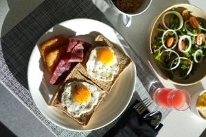 a plate of breakfast food with eggs and toast at Four Points by Sheraton Bekasi in Bekasi