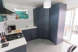 une cuisine avec des placards bleus et un comptoir blanc dans l'établissement 4 Bedroom cosy home Birmingham, à Birmingham