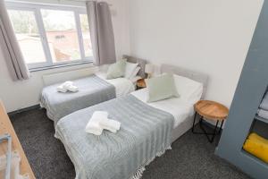 une chambre d'hôtel avec deux lits et une fenêtre dans l'établissement 4 Bedroom cosy home Birmingham, à Birmingham