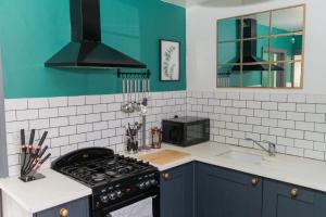 Il comprend une cuisine équipée d'une cuisinière. four supérieur à côté d'un évier dans l'établissement 4 Bedroom cosy home Birmingham, à Birmingham 22 autres photos
