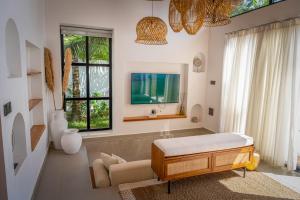 a living room with a bed and a tv at Paje Emerald Escapes in Paje +51 photos
