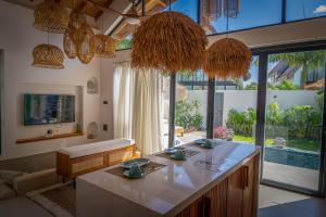 a living room with a kitchen with a large window at Paje Emerald Escapes in Paje