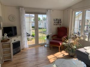 a living room with a couch and a chair and a television at ZP 470 - Camping de Zandput in Vrouwenpolder