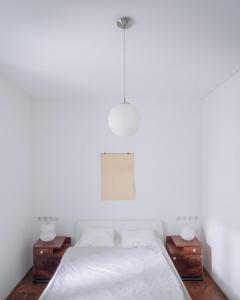 KolibaにあるArchitects cozy getawayの白いベッドルーム(ベッド1台、ナイトスタンド2台付)