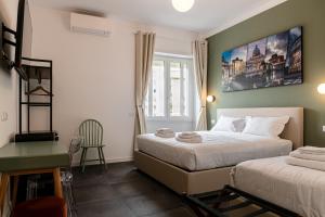 a bedroom with a bed and a desk and a window at Flora Guest House in Rome +61 photos