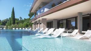 a row of white lounge chairs next to a building at Amadria Park Grand Hotel 4 Opatijska Cvijeta in Opatija