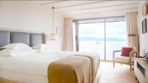 a bedroom with a large bed and a large window at Amadria Park Grand Hotel 4 Opatijska Cvijeta in Opatija